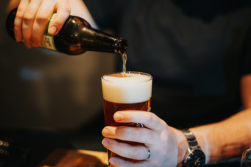 A person pours a non-alcoholic beer.